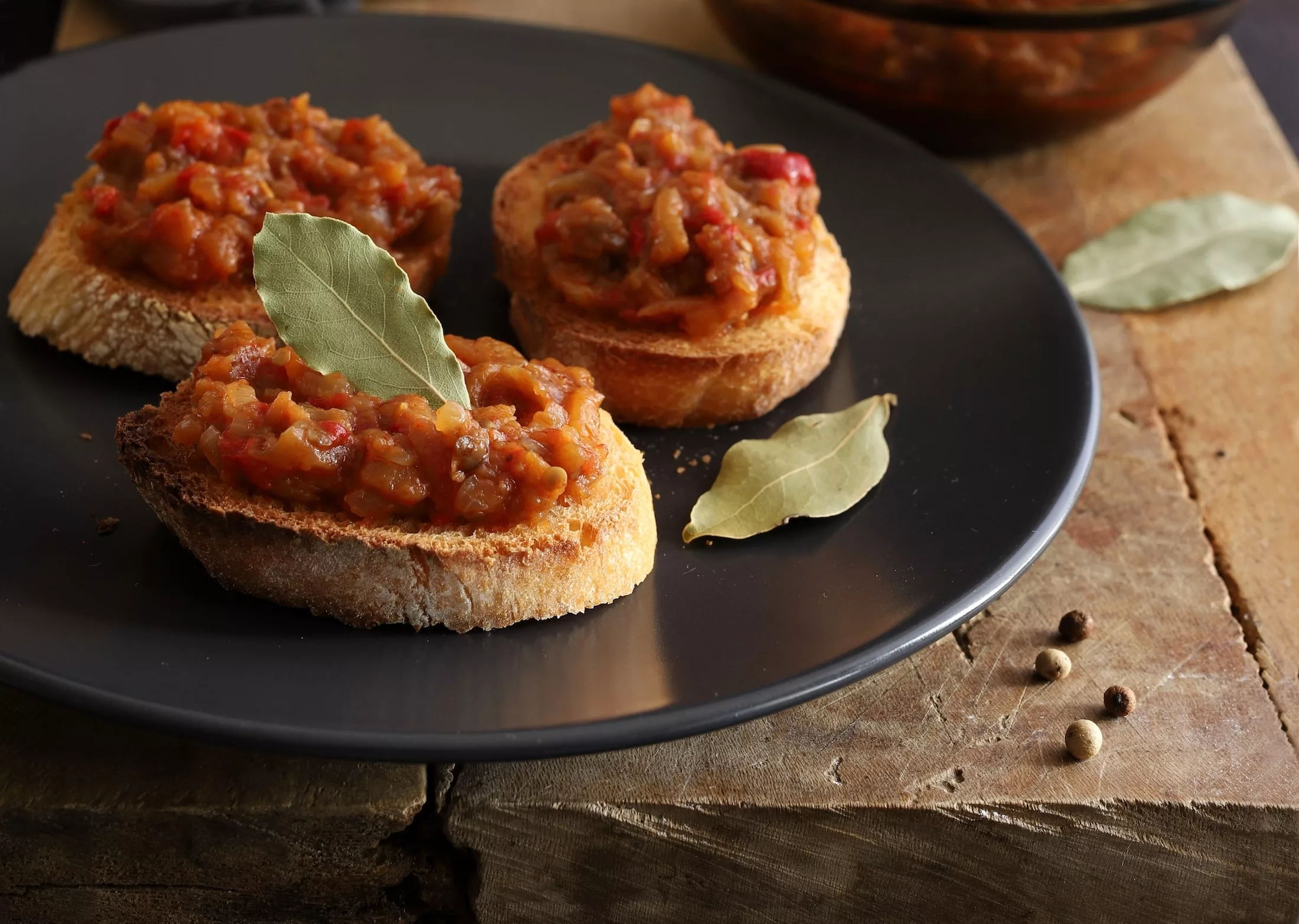 Zacusca - Romanian food. Slices of bread with vegetable spread, roasted eggplant, onions, tomato paste and roasted red peppers. Autumn and vegetarian food.